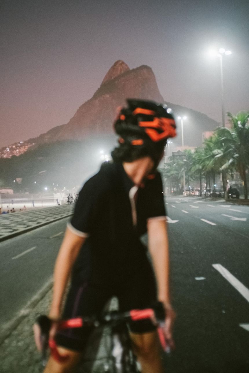 Cyclist riding the bike with a mountain backdrop at night near Janeiro Hotel