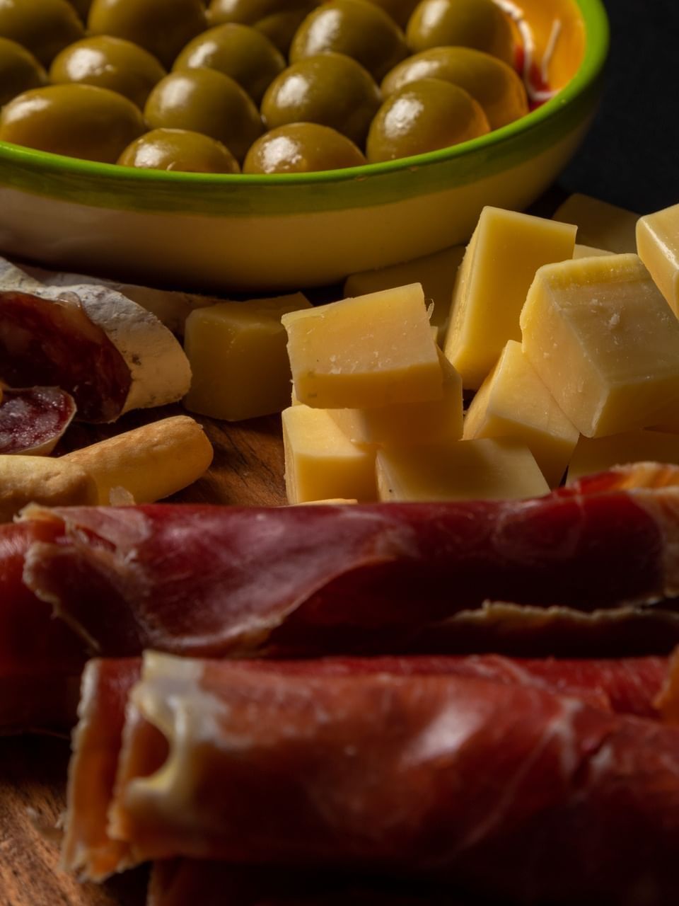 Wooden platter featuring assorted cured meats, and cheese cubes in Vinos & Tapas restaurant at El Conquistador Resort