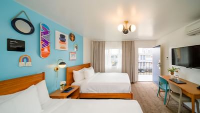Double beds and work area with balcony in Superior Two Queen Room at Becks Motor Lodge
