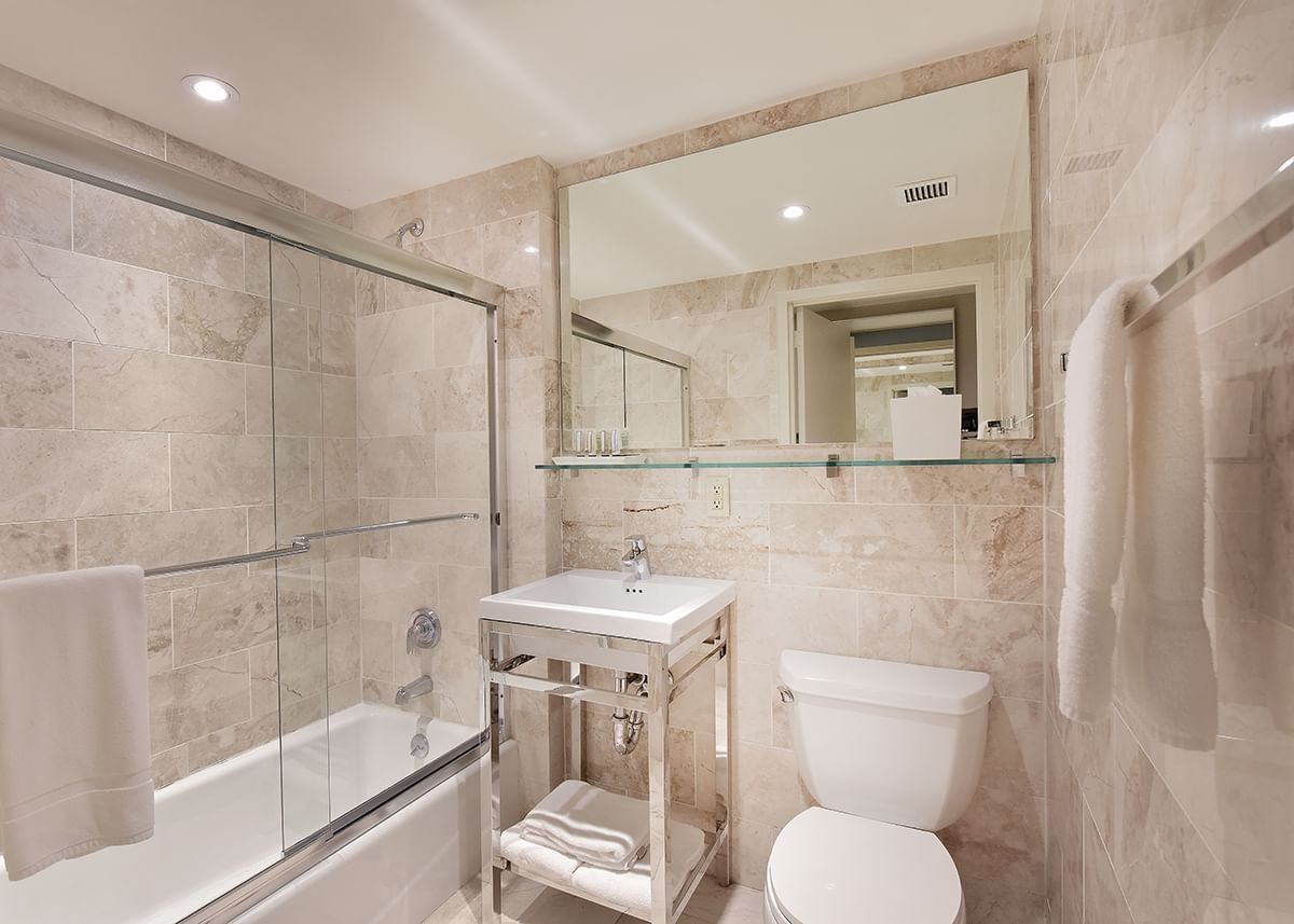 A clean and modern bathroom with a shower, bathtub, toilet, sink, and mirror.