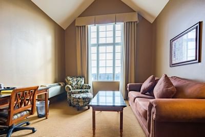 Spacious living area with plush seating and carpeted floors in Standard King at The Wildwood Hotel
