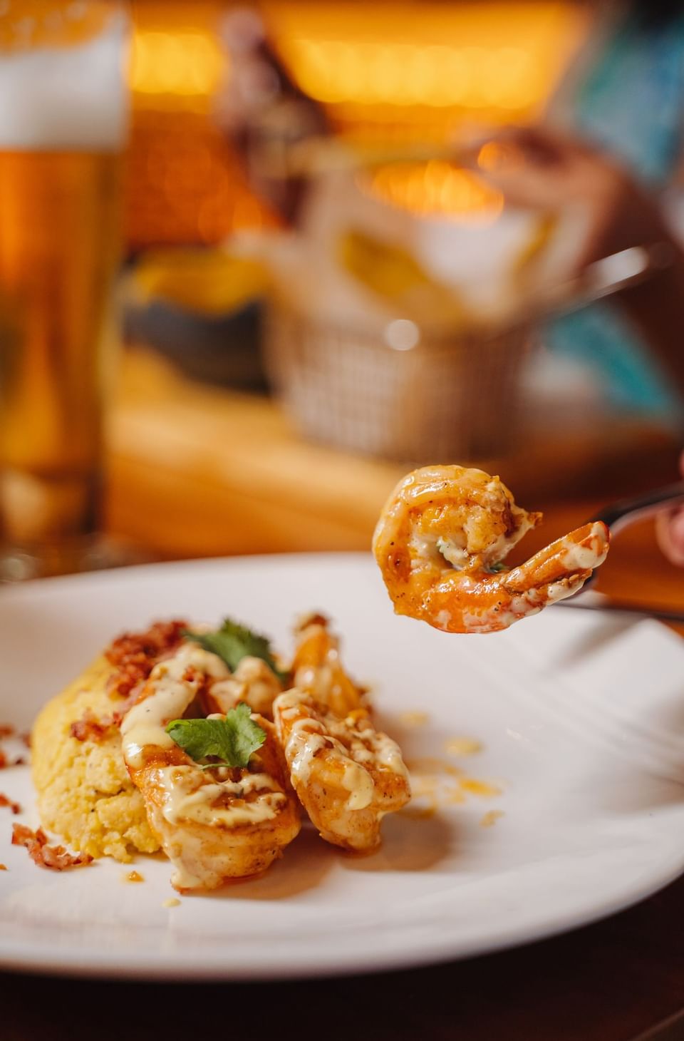 Seasoned shrimp plate with a person picking one up in Bazul at Indura Beach & Golf Resort