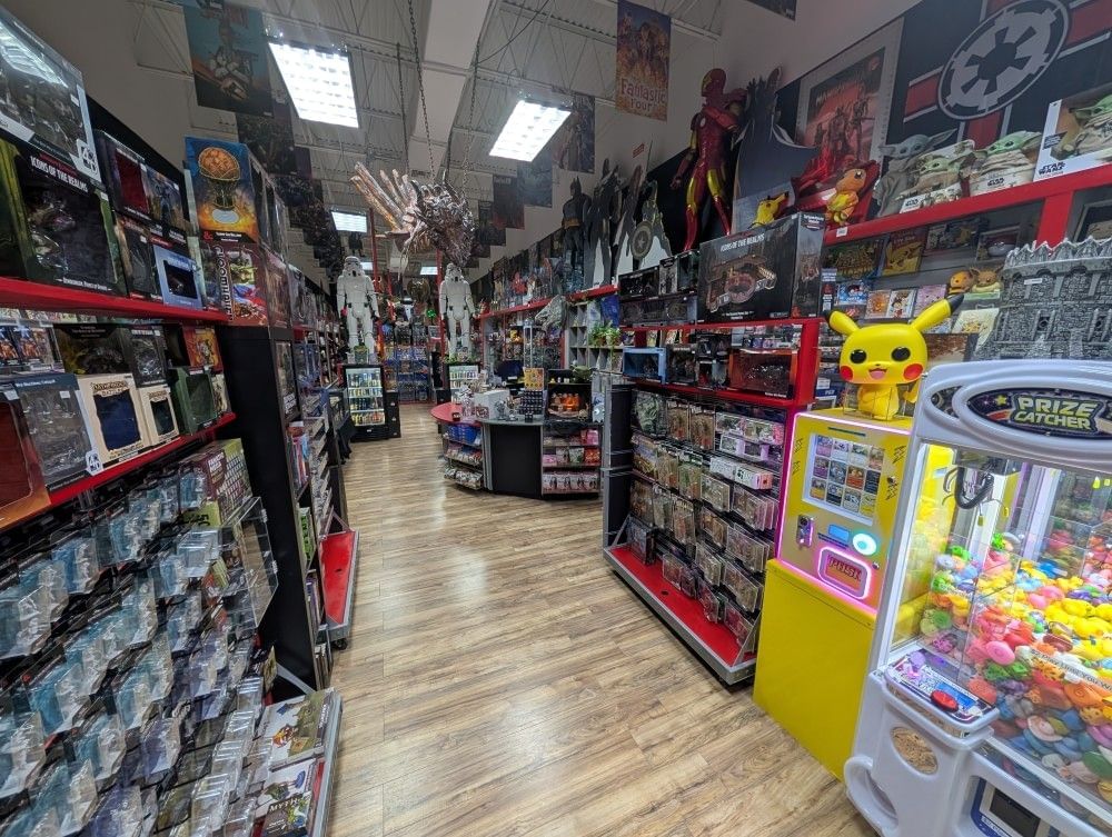 The interior of a toy store with shelves lined with collector's items and large comic book figures. 