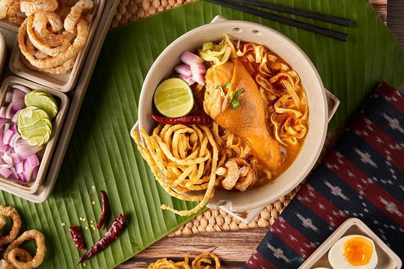 Garnished Khao Soi Chicken dish served at U Hotels & Resorts