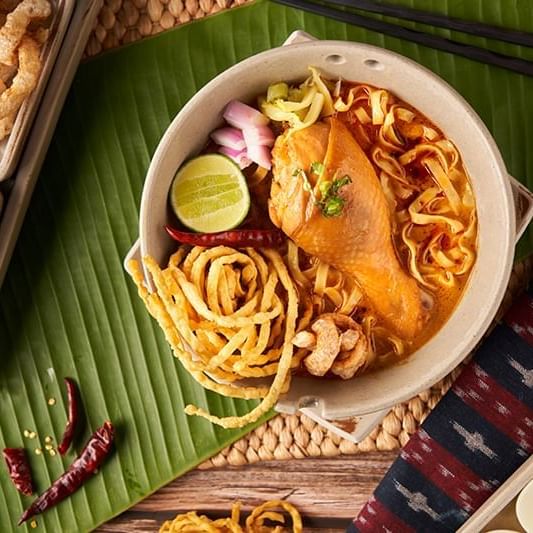 Close-up of Khao Soi chicken dish served at U Hotels & Resorts