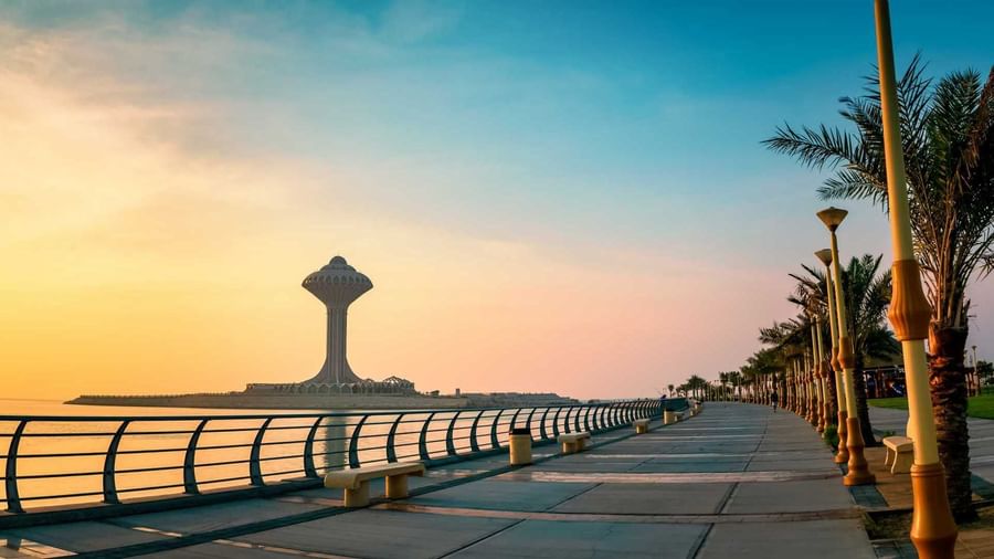 Coastal walkway with benches and palm trees leading to a Al Khobar Water Tower near Warwick Al Khobar