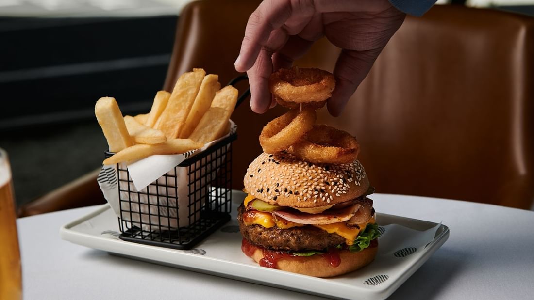 Close-up of burgers and fries served in Mortimer's Lounge at Pullman Albert Park