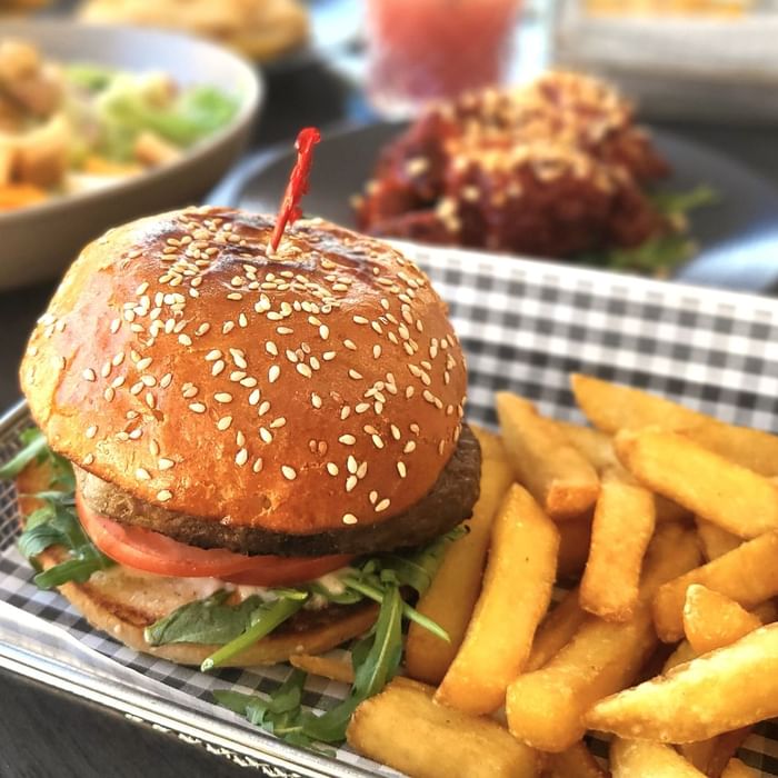 Burger with crispy french fries served in a tray at Celsius Restaurant & Bar by Mercure Hotel Townsville