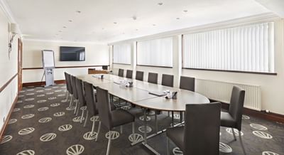 Loirston Suite boardroom at The Aberdeen Altens Hotel with a long table and a large wall-mounted TV
