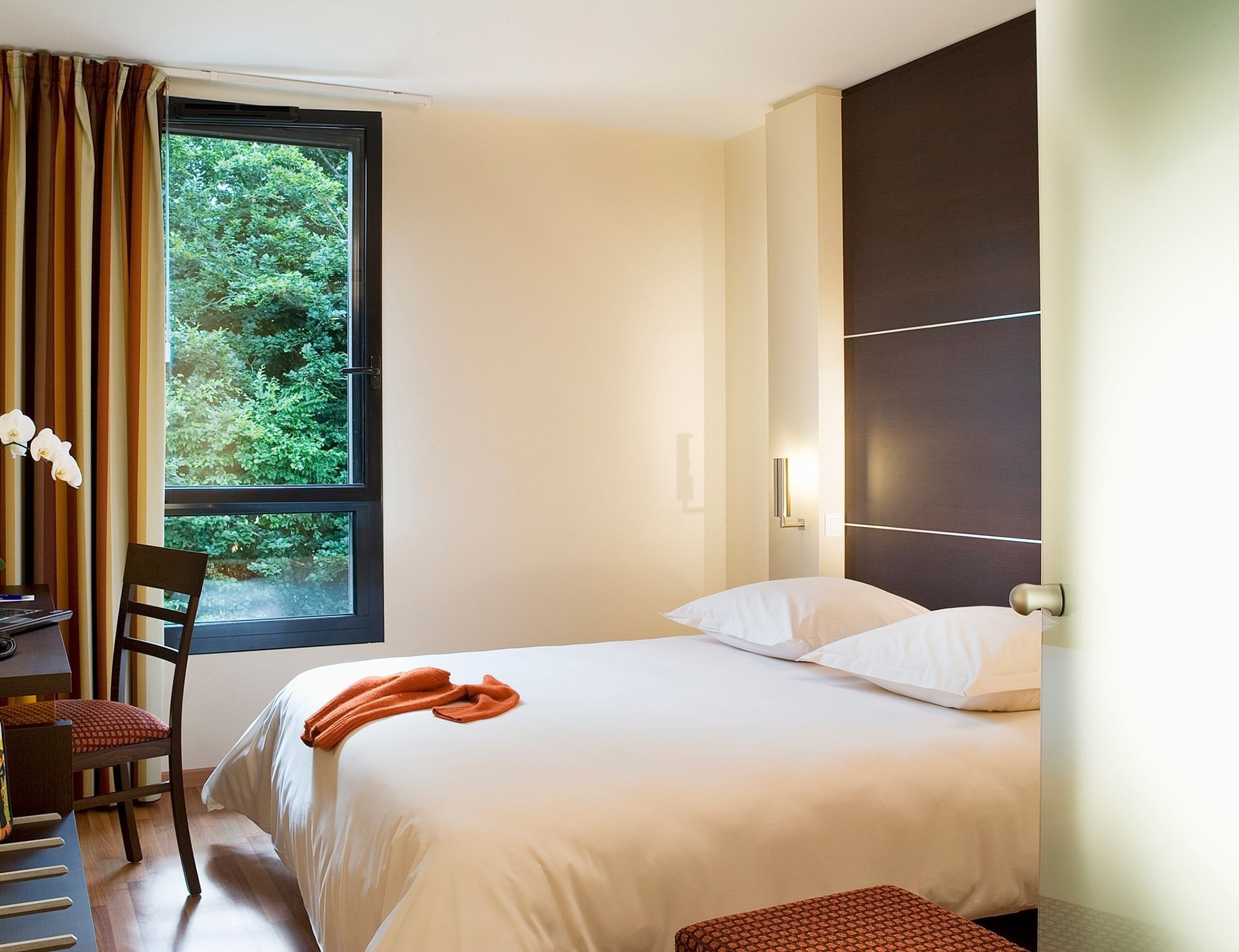 Lit king-size et bureau dans une chambre à l'Escale Oceania Rennes