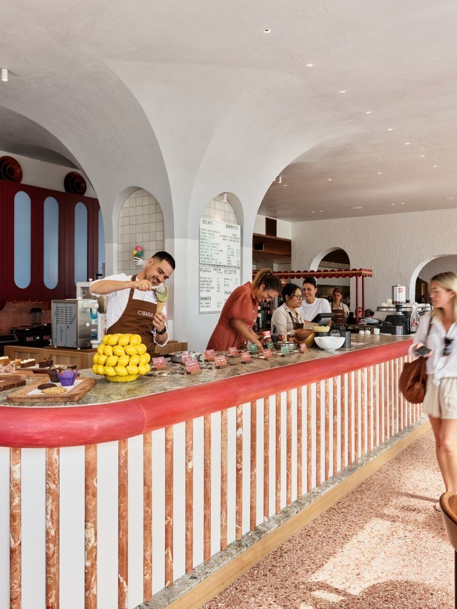 Cibaria Caffetteria & Gelateria at Elysium Manly features servers behind a counter by blue tables under arches
