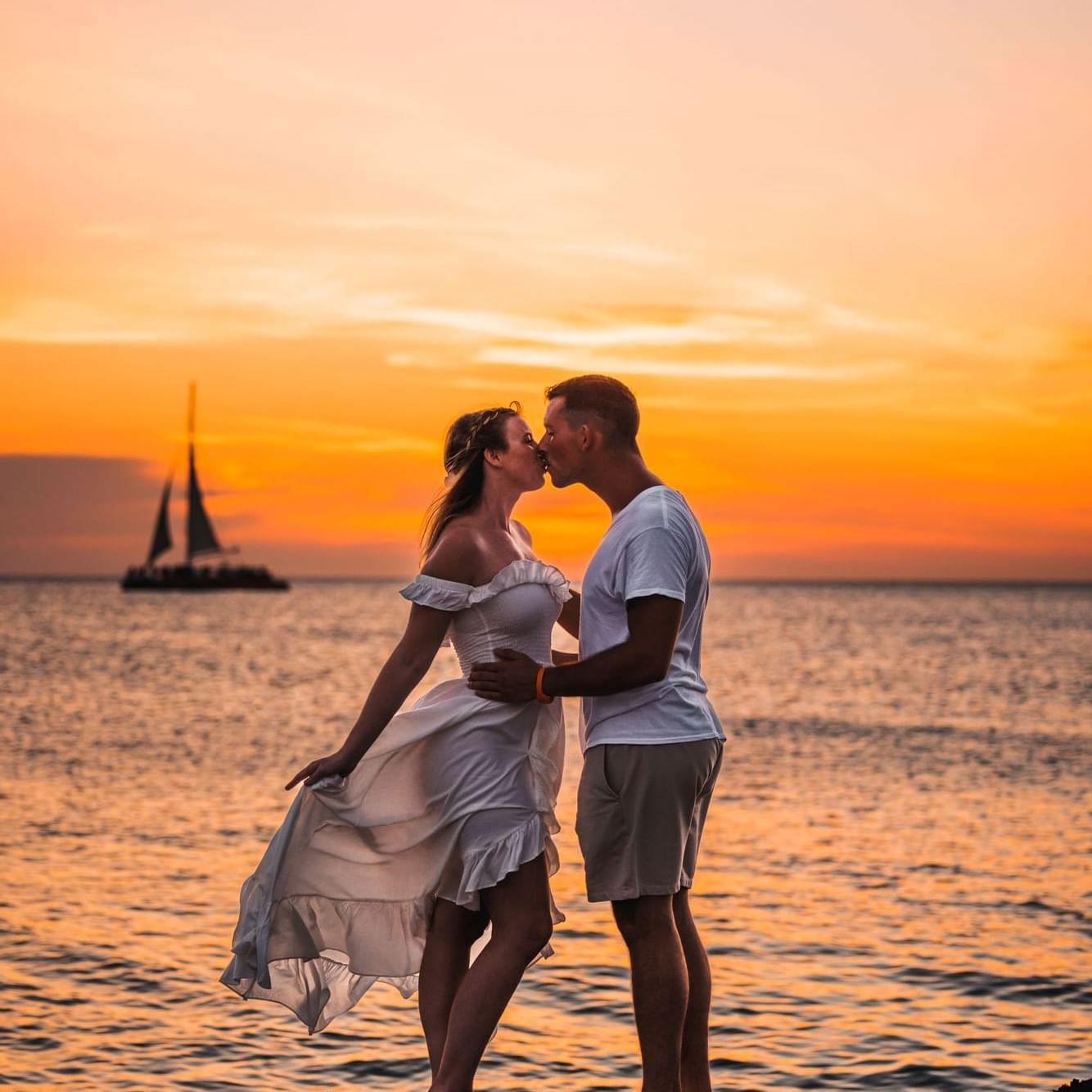 Romantic couple kissing on the beach at sunset near Amsterdam Manor Beach Resort Aruba