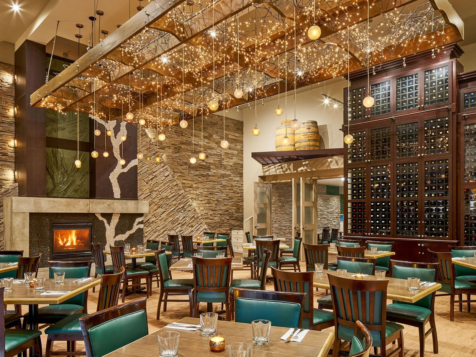Modern restaurant with a fireplace, stone accents, and a unique illuminated ceiling at the Varscona Hotel on Whyte