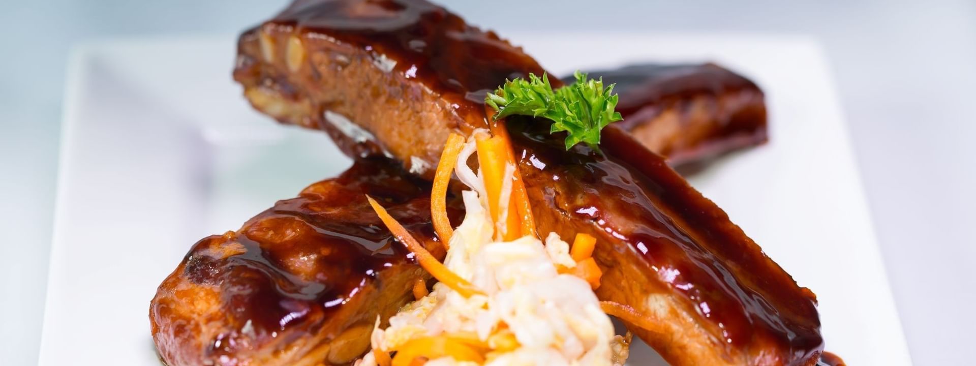 BBQ ribs by a pile of fresh coleslaw under a small parsley leaf in Tings on a Stick at Warwick Paradise Island Bahamas