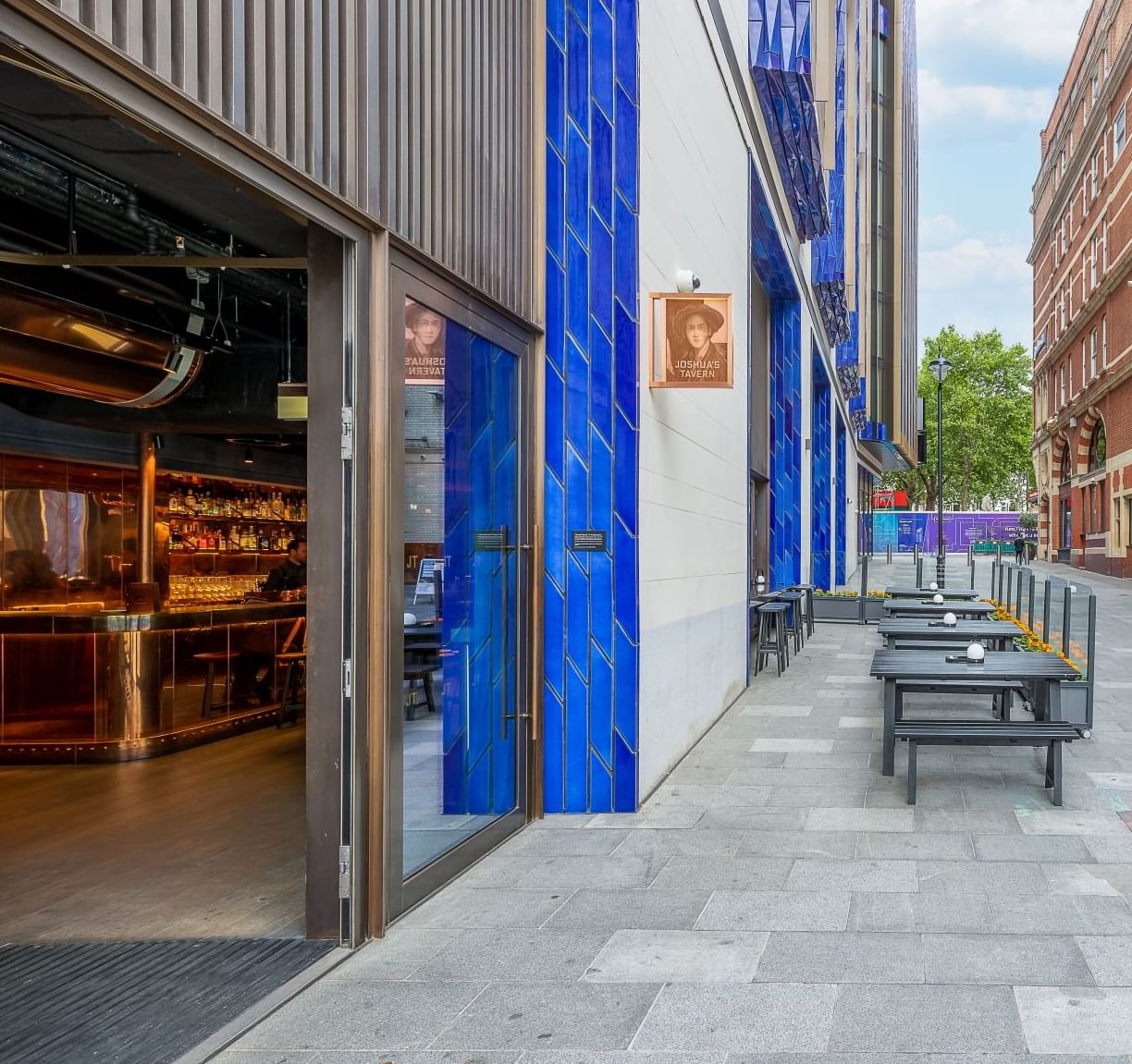 Exterior street view featuring the entrance of Joshua's Tavern with classic signage at The Londoner Hotel