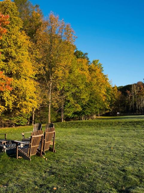 Firepit surrounded by wooden lounge area in the garden at Cove Pocono Resorts
