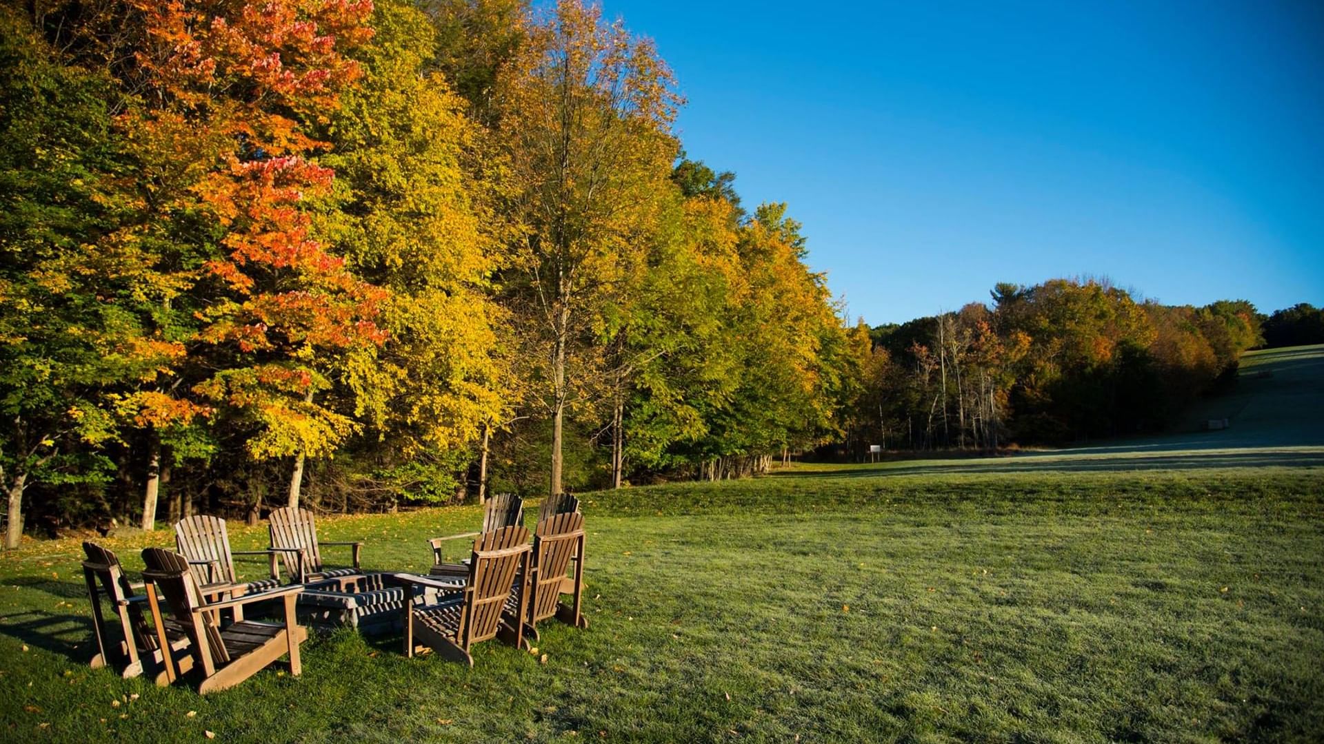 Firepit surrounded by wooden lounge area in the garden at Cove Pocono Resorts