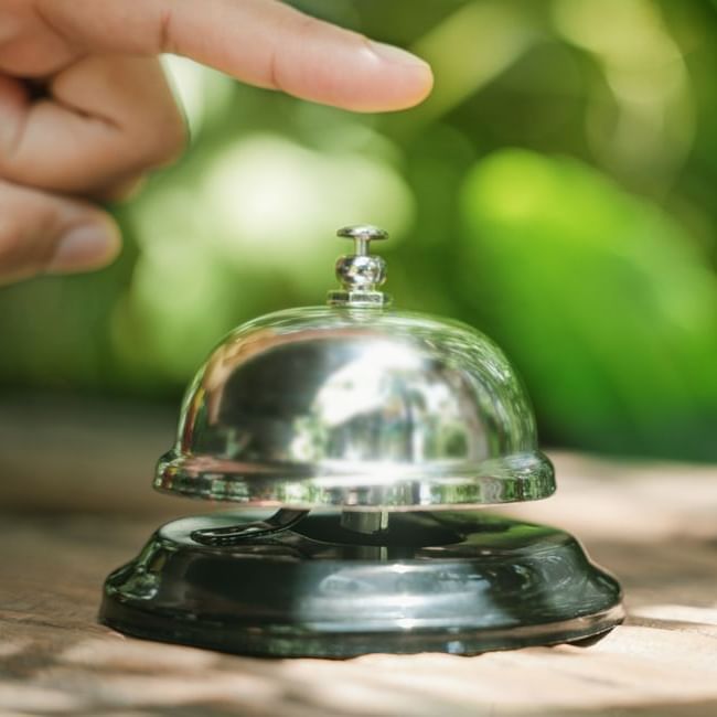 Close-up of a person pointing at a bell on a table at Imperial Lexis 5 star hotel in Kuala Lumpur