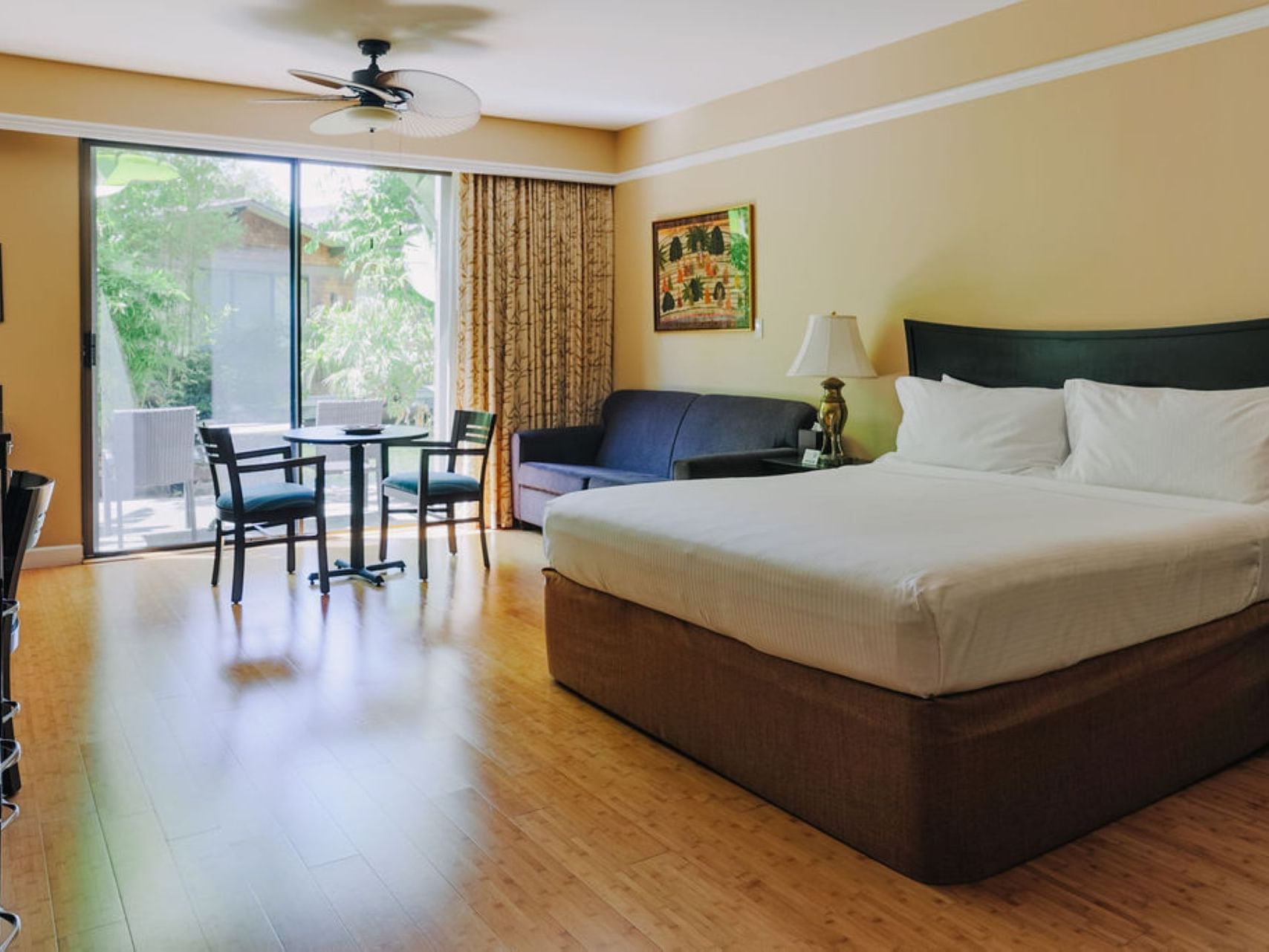 Large bed & balcony in Patio Room at Dinah's Garden Hotel