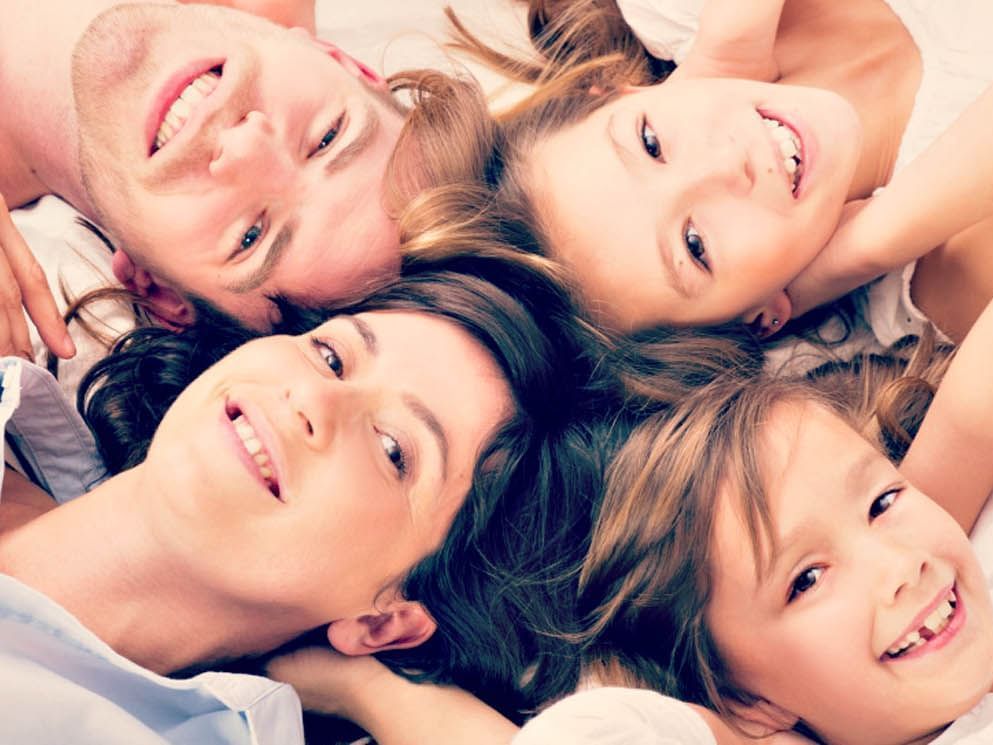 Headshot of a family lying down on a bed at Warwick Geneva