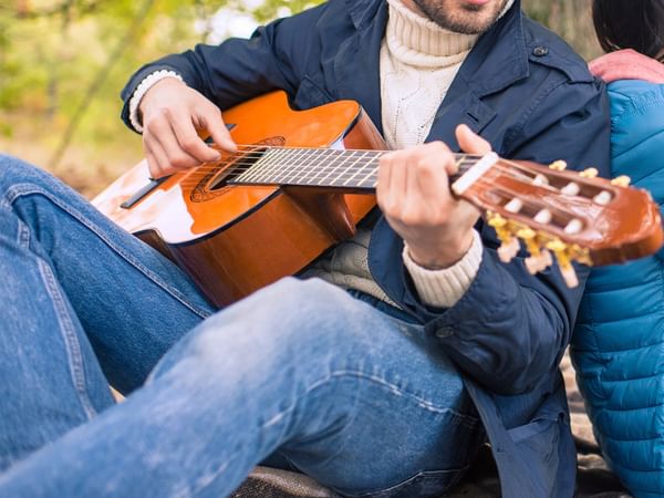 Man playing guitar in nature.