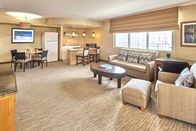 Living area with loungers, dining table & an kitchenette in Two Bedroom Penthouse Suite at Waikiki Resort Hotel by Sono