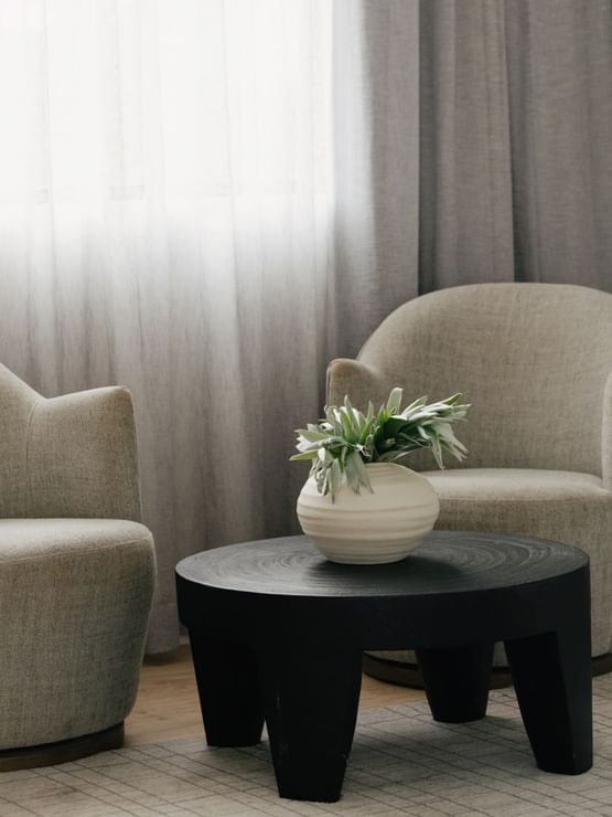 Sunset Junior Suite at Elysium Manly featuring two grey armchairs by a black round coffee table, best places to stay in Manly