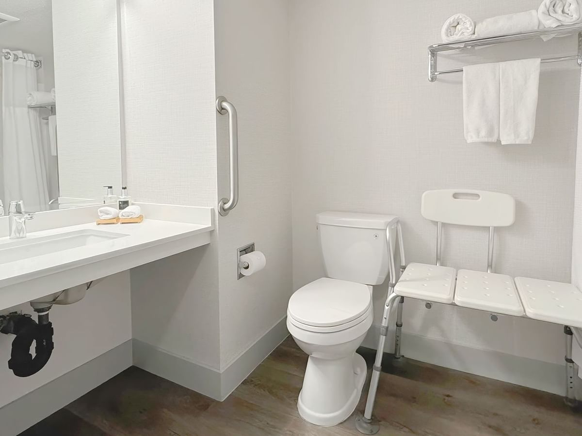 Accessible washroom with toilet, bathtub, soap, sink and towel
