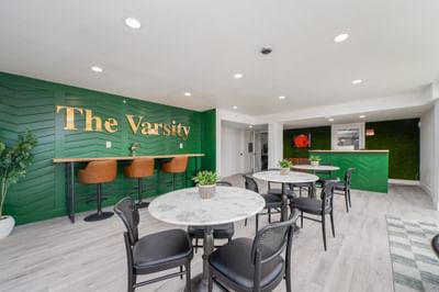 Spacious lobby lounge with cafe seating and a green chevron feature wall in Centralia hotels at The Varsity South