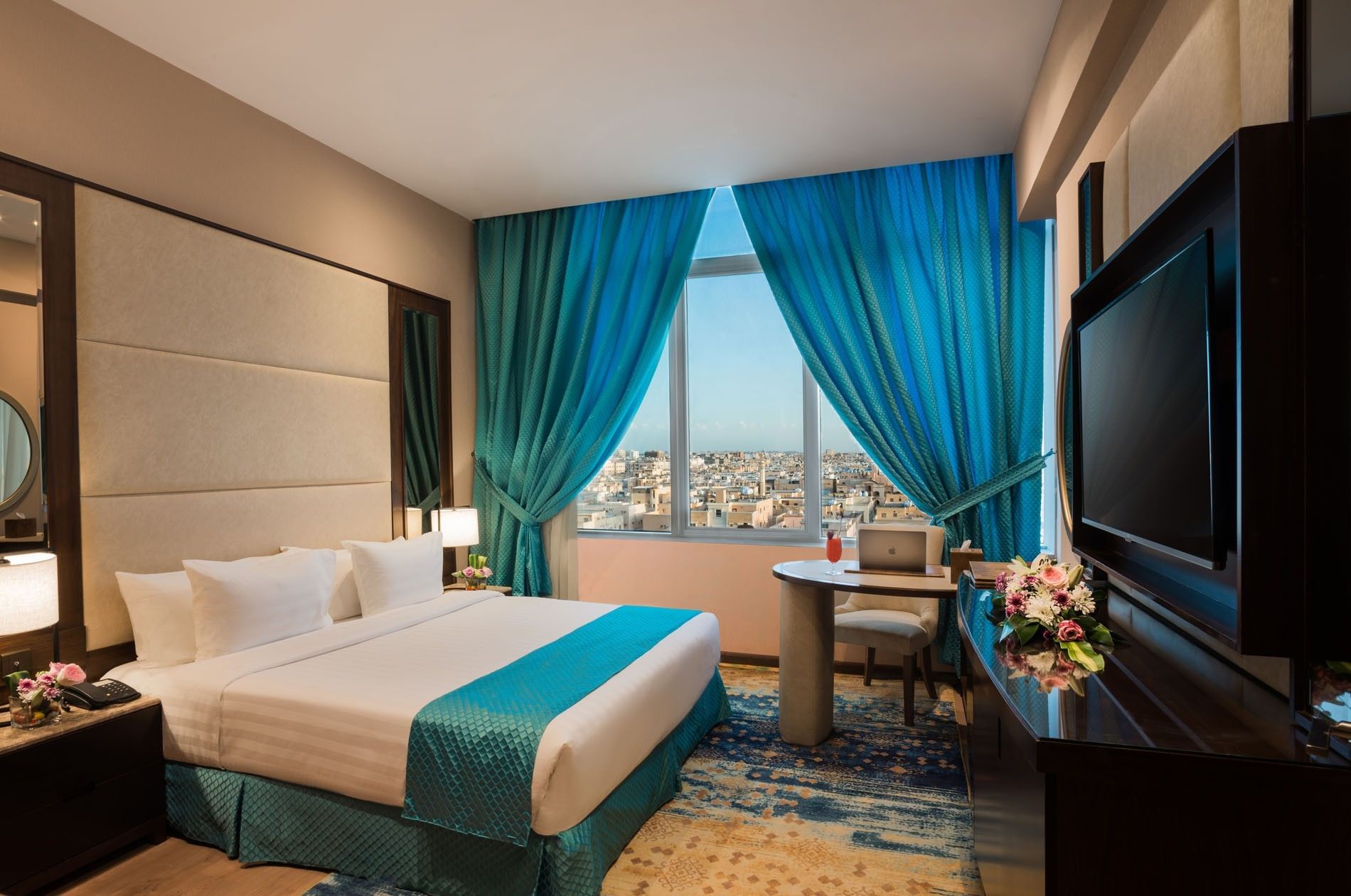 TV facing the bed with a work desk near window in Executive suite at Naviti By Warwick Dammam