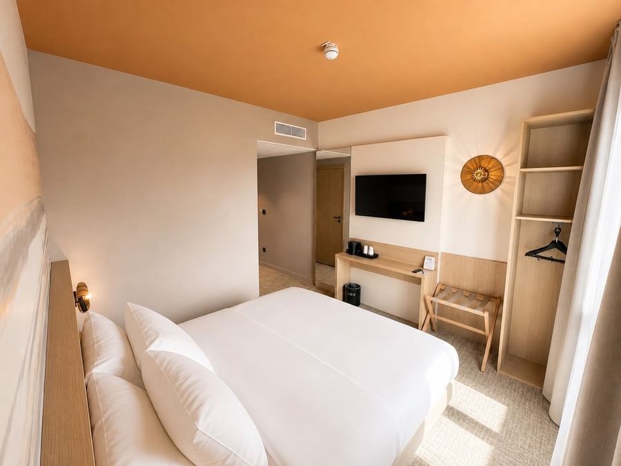 Chambre double confortable avec télévision et mobilier moderne chez Osmo Hôtel à Chantepie.