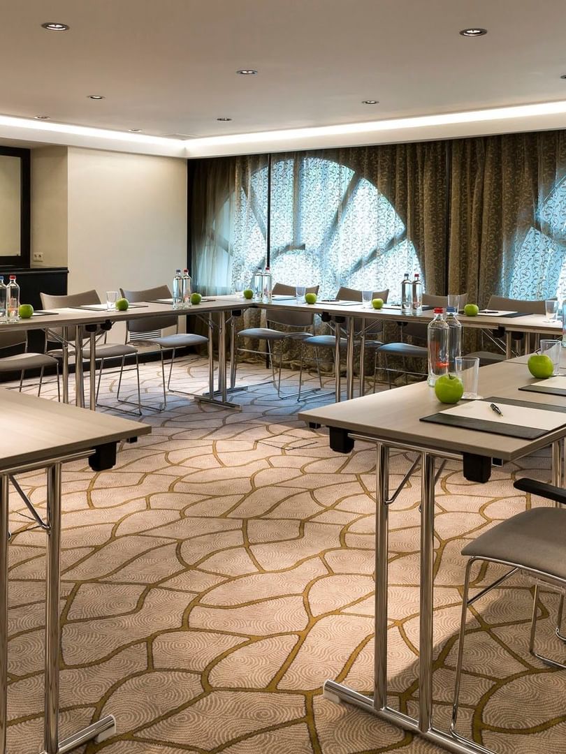 Lege evenementenzaal Barsey II met vloerbedekking en ramen in Hotel Barsey by Warwick Brussel.