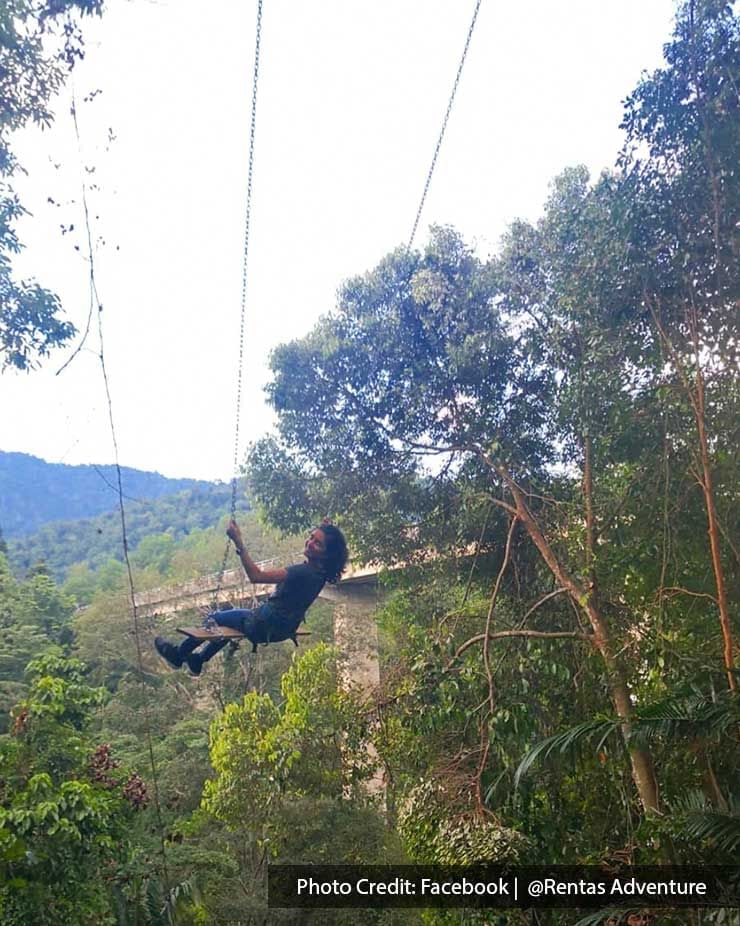 A woman were zip-lining through a forest - Lexis Suites Penang