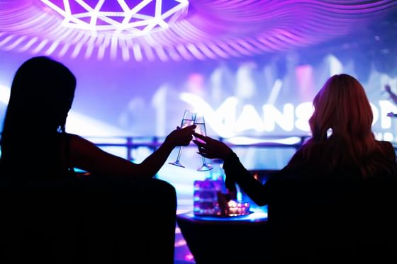 two women making a toast at Mansion Nightclub