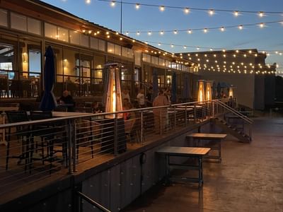 Cozy outdoor restaurant with string lights, patio heaters, and tables set for dinner at Off Shore Resort
