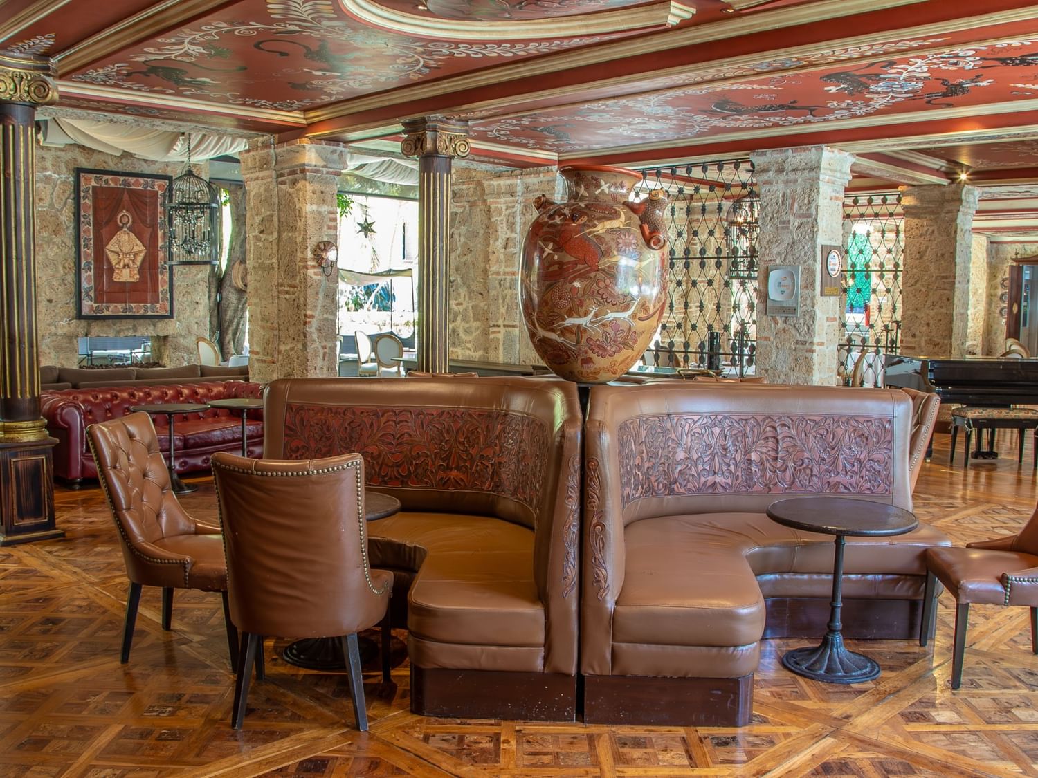 Tierra Mia restaurant features curved leather banquettes, ornate ceiling, and stone walls at Quinta Real Guadalajara