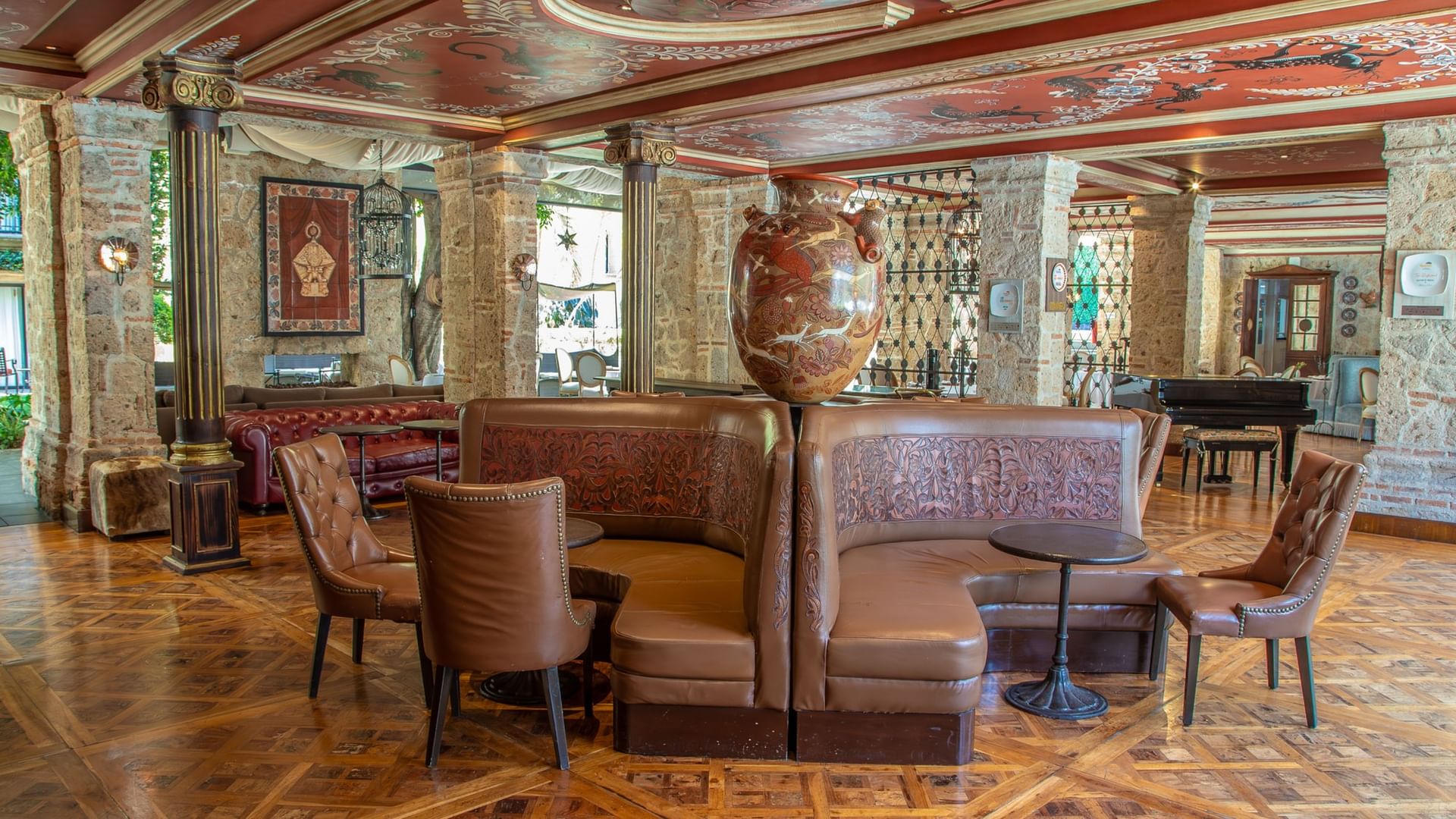 Tierra Mia restaurant features curved leather banquettes, ornate ceiling, and stone walls at Quinta Real Guadalajara