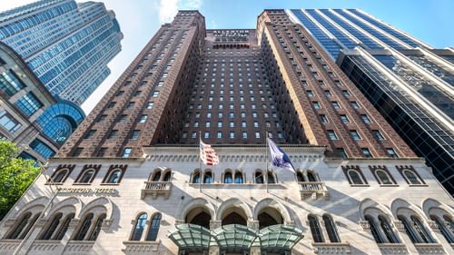 Exterior of the Warwick Allerton Chicago, featuring grand entryways by tall, surrounding buildings