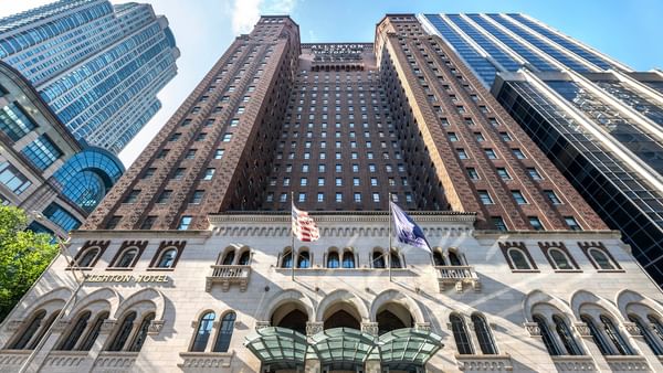 Tall building with many windows and two flags at Warwick Allerton - Chicago.