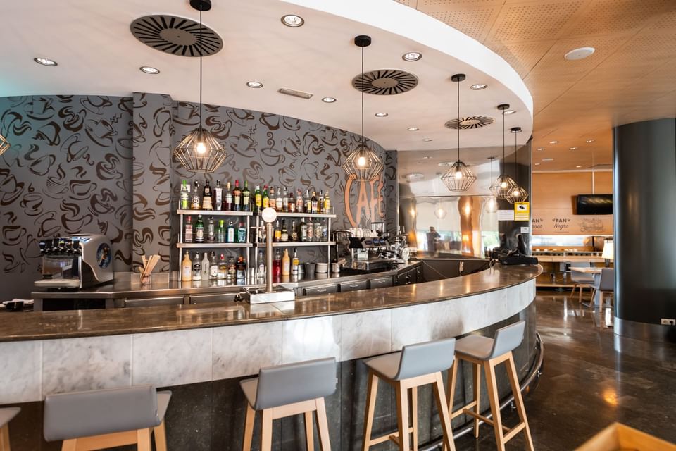 Bar counter, stools & shelves with bottles in Mini Bar at Hotel Vila Centric