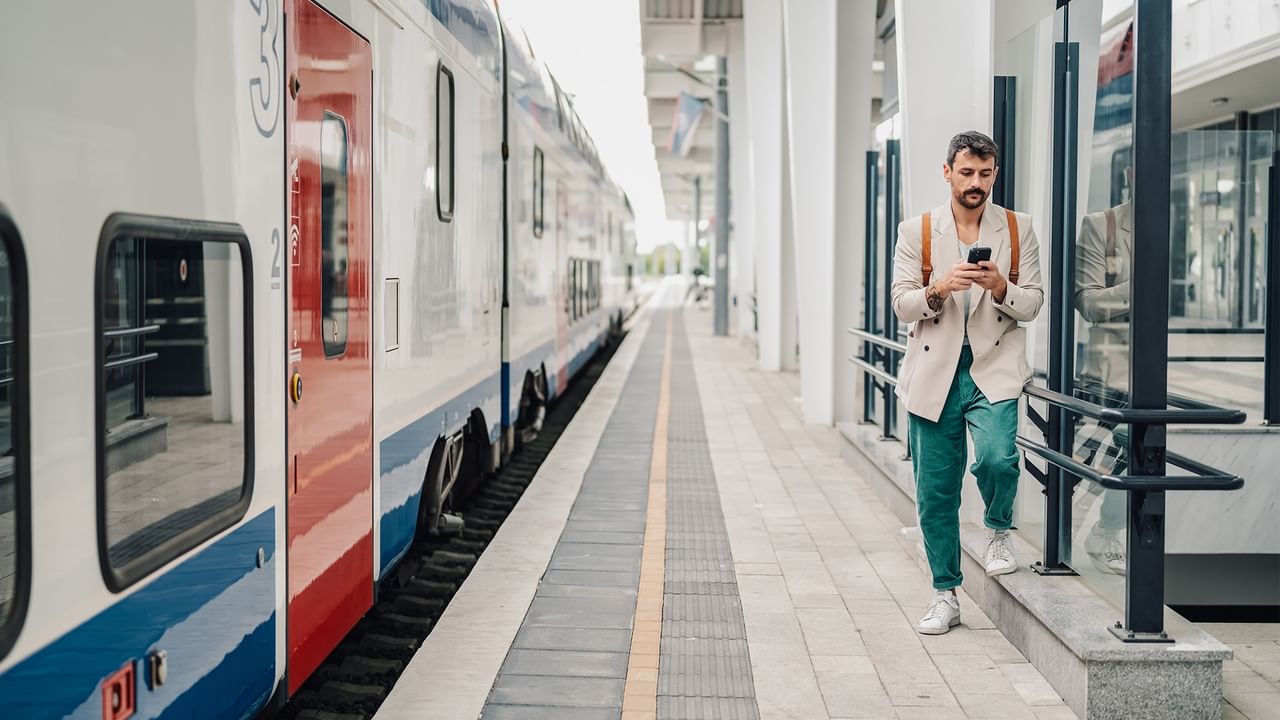 a man on his phone at a train station