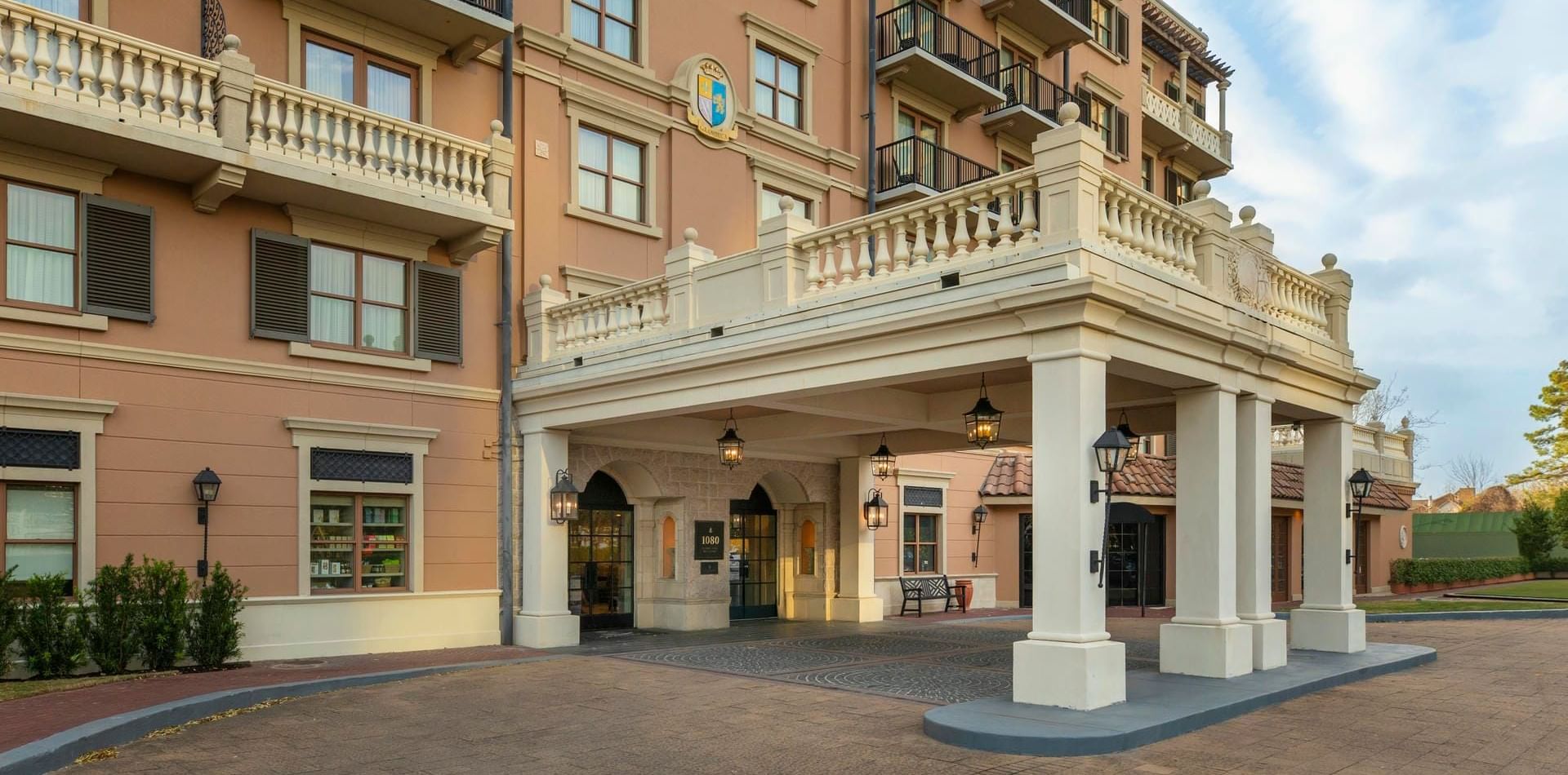 Luxurious entrance of Granduca Houston with a grand portico and balconies framed by a clear blue sky