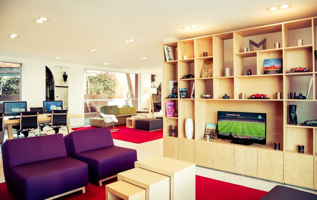 Área de TV y sala de estar en el lobby del hotel en Gamma Hotels