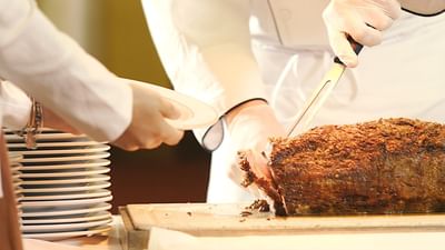 Chef slicing roast dish.