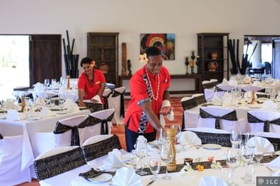 Set tables in a dining hall with white linens at Musket Cove Island Resort & Marina
