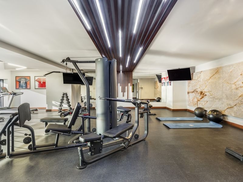 Well-equipped Wellness Center featuring weight machines, yoga mats, and modern ceiling lights at Sunvivia Mazatlán