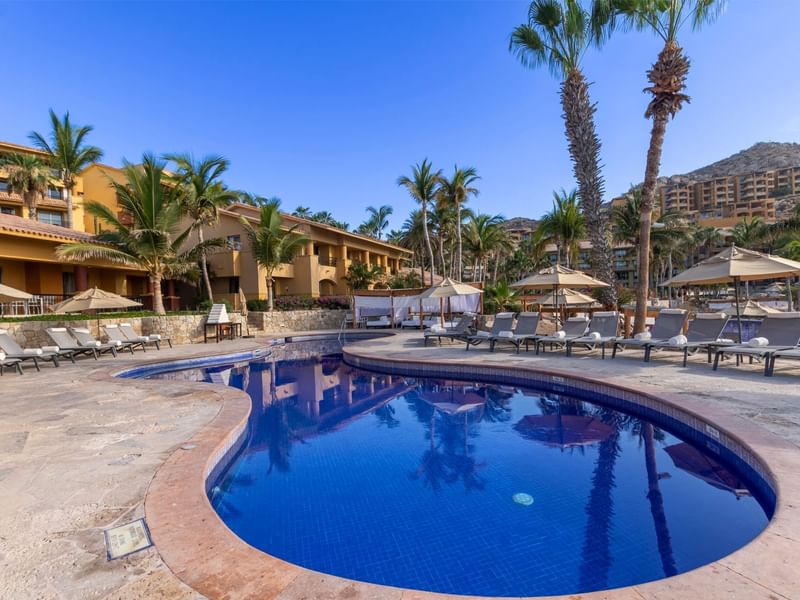 Outdoor pool area with sun loungers and patio umbrellas at Grand Fiesta Americana