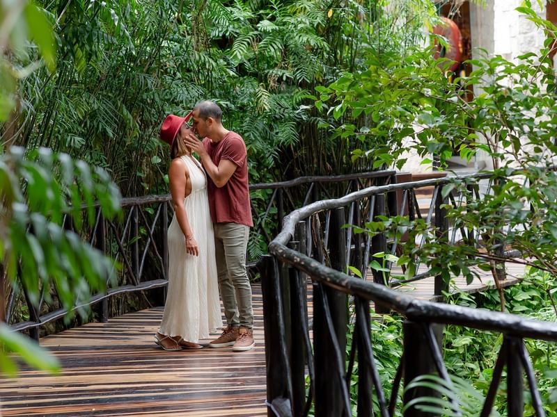 A couple kissing on wooden bridge at The Reef Playacar