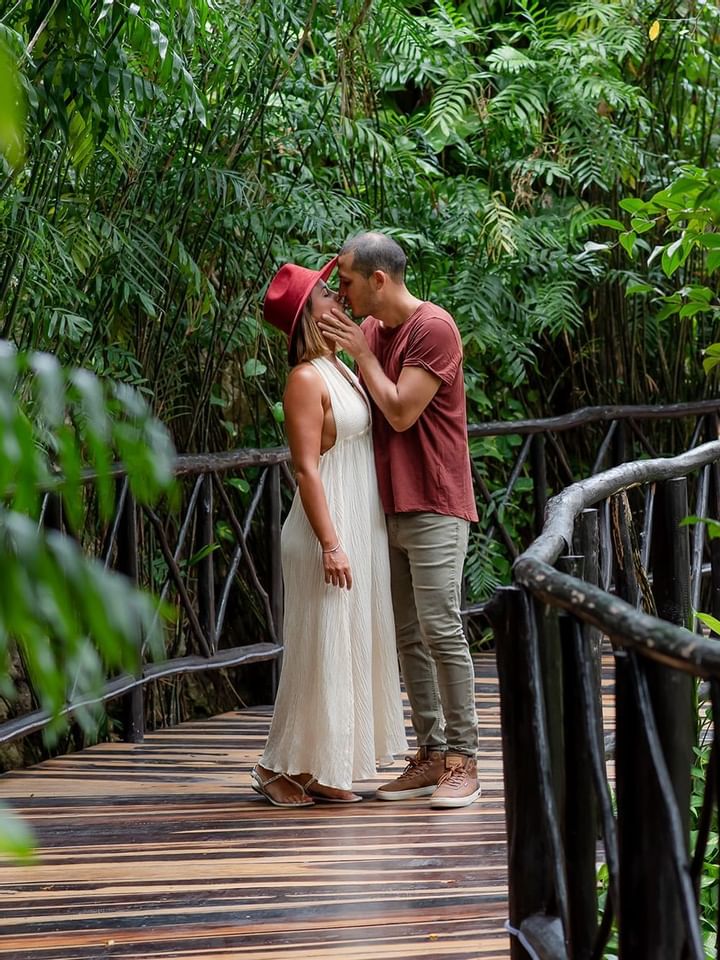 A couple kissing on wooden bridge at The Reef Playacar