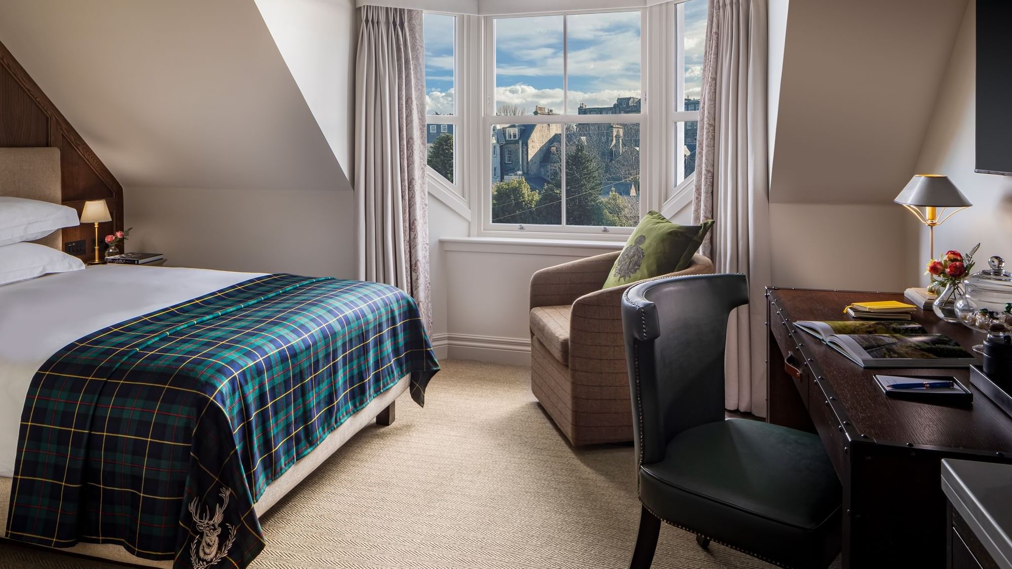 Work desk and couch facing the bed by the window in Deluxe at Seaton House